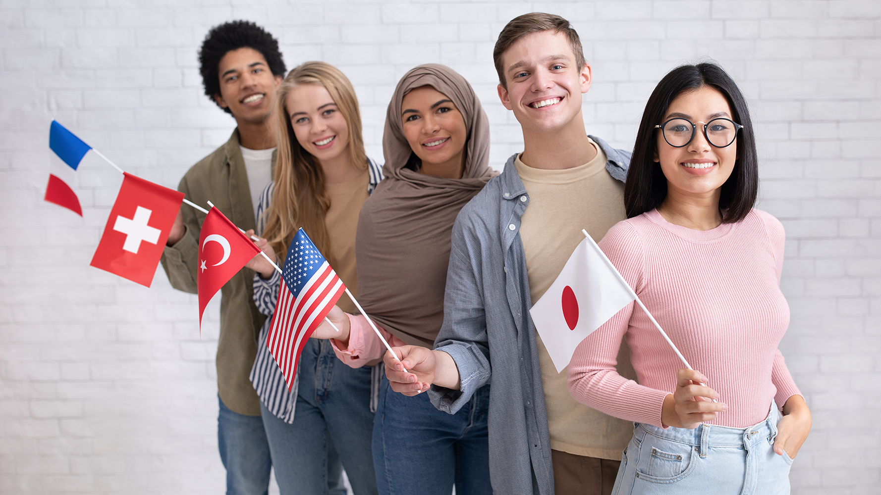 Fünf Studentinnen und Studenten stehen in einer Reihe und halten ihre Landesflagge