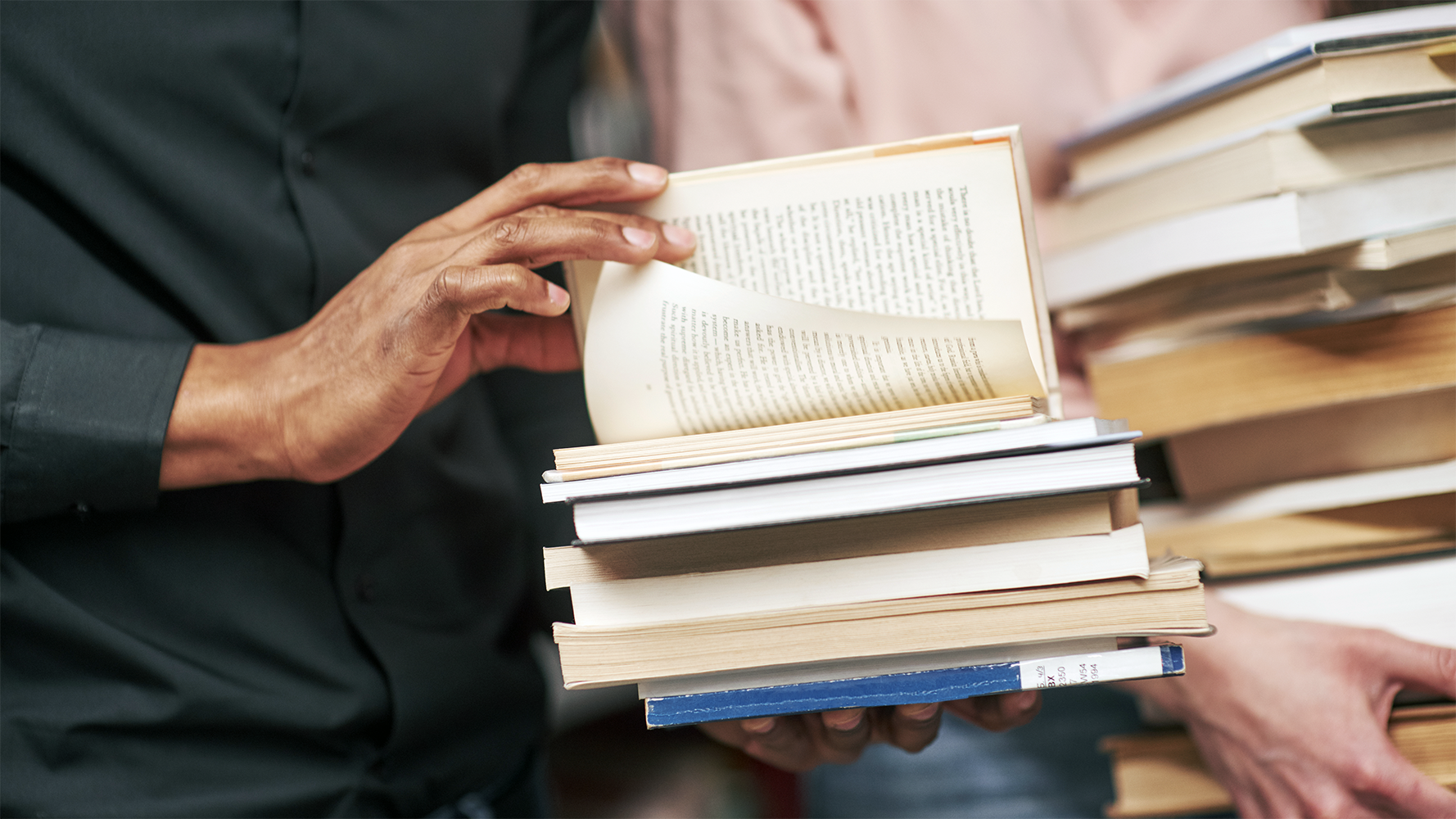 Foto von Büchern, die ein Mann in den Händen hält