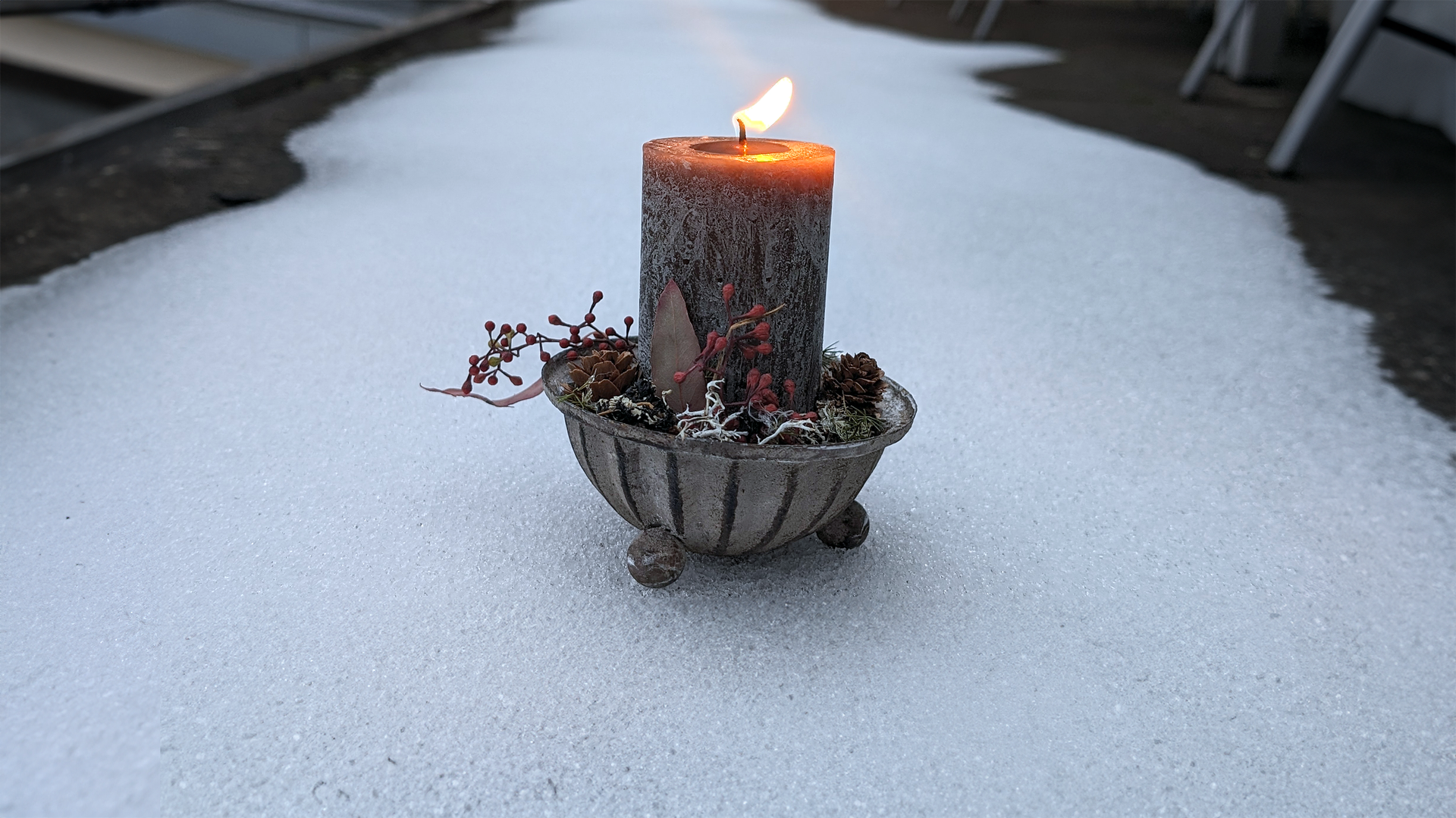 Brennende Kerze auf Schnee