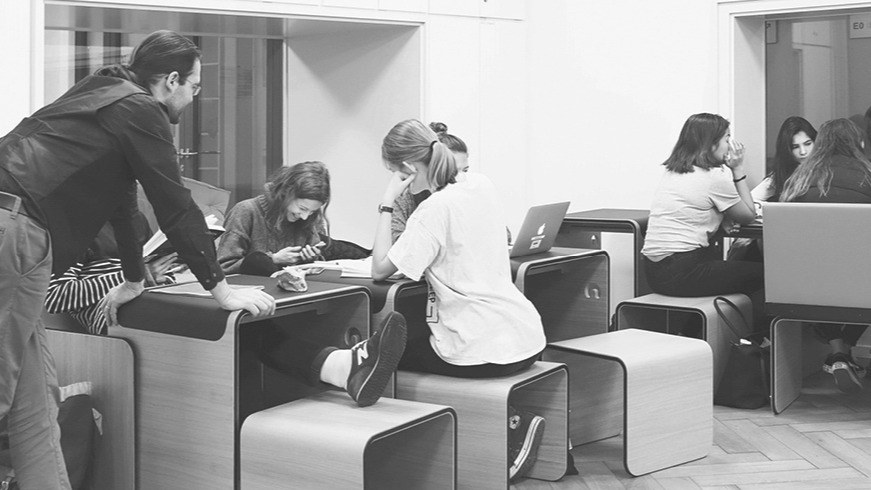Studierende sitzen vor verschiedenen Devices herum