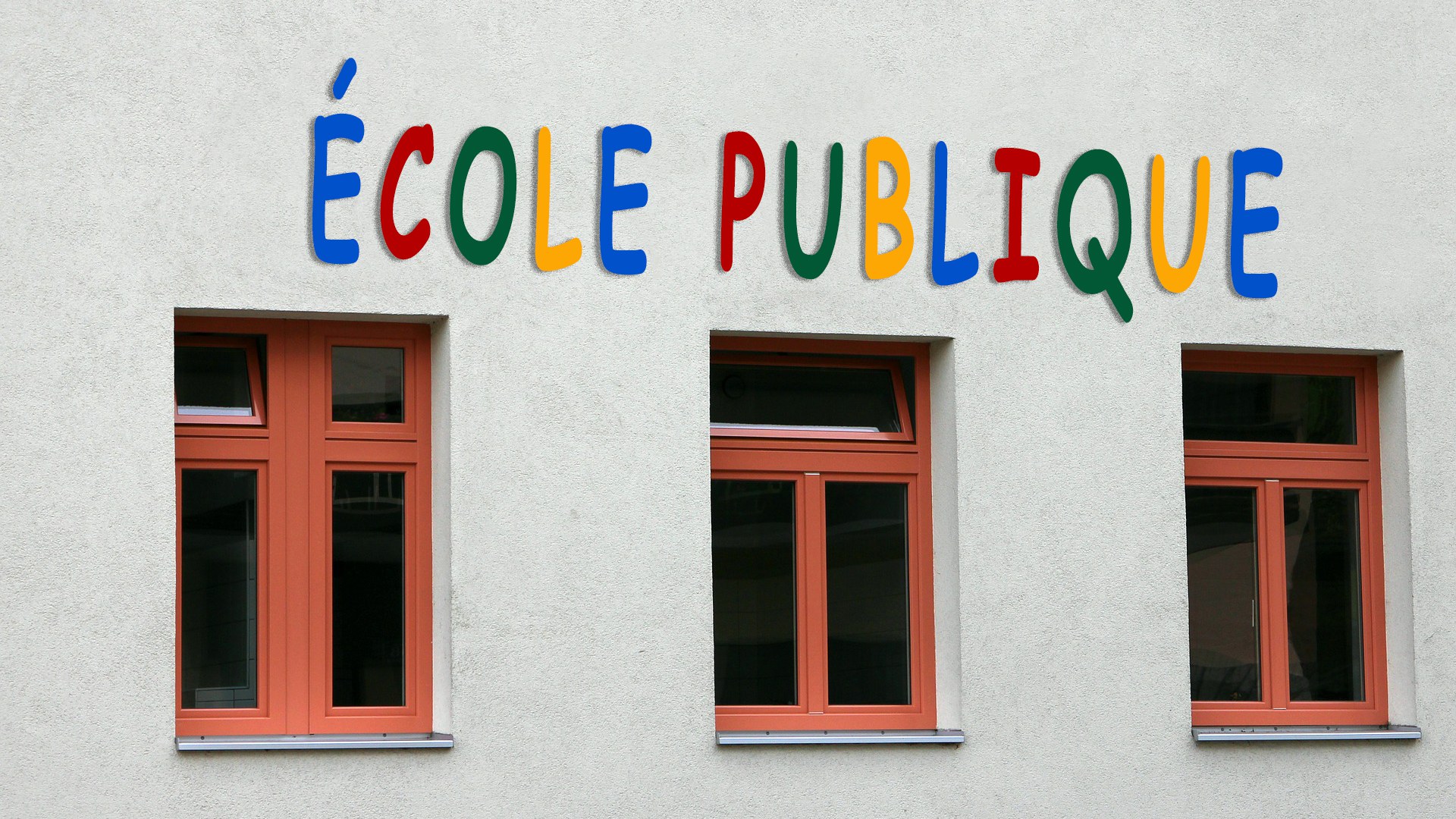 Photo d’une façade avec trois fenêtres rouges au-dessus desquelles est écrit «école publique» en lettres de différentes couleurs