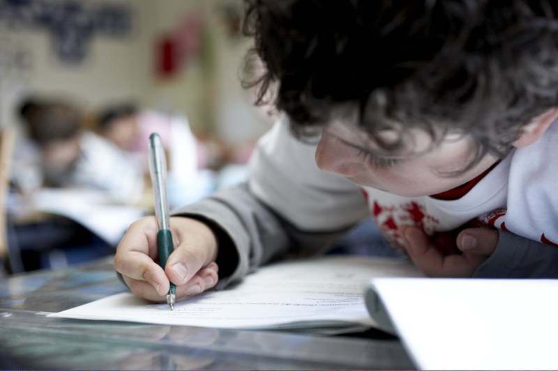 Un enfant concentré écrivant dans un cahier